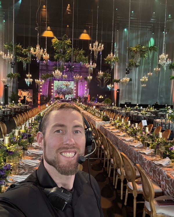 George Cannon III wearing a headset at a gala he is lighting