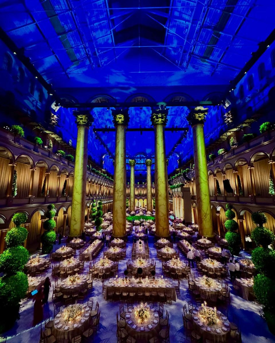 Ballroom-style dinner lit in deep blue beneath the National Building Museum columns
